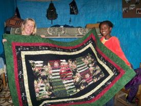 Mary giving a quilt to Fregenet, who shares her top bunk with Tigist.