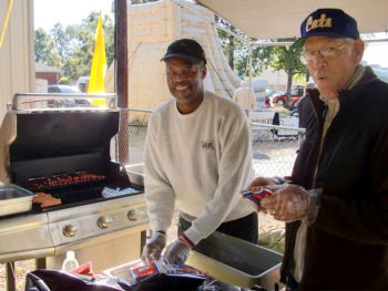 Men cooking hot dogs